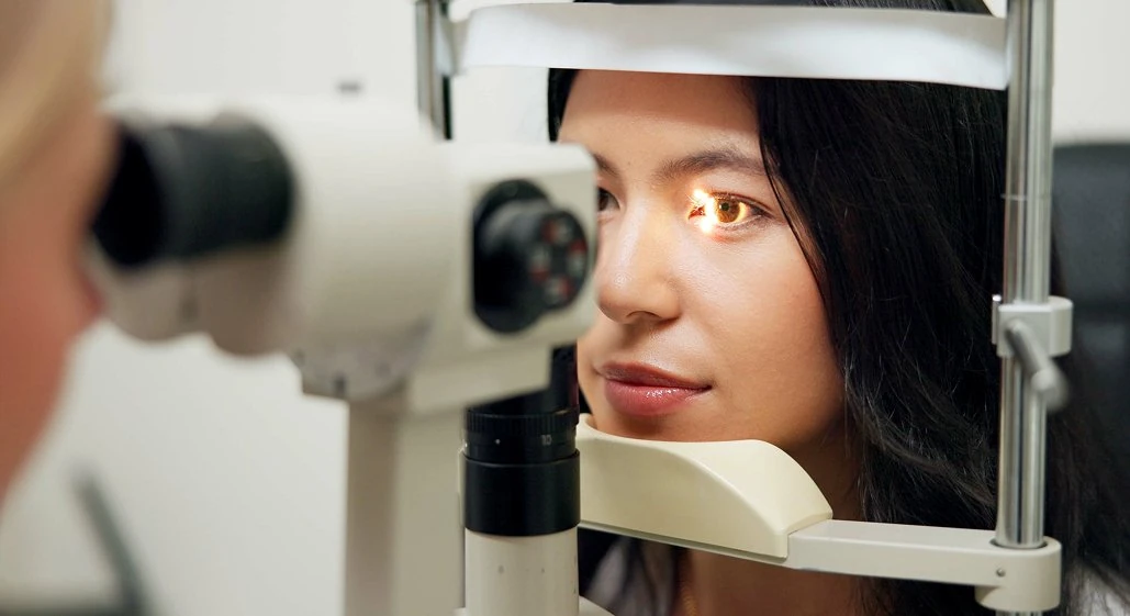 A patient having her eyes examined at a slit lamp during a laser eye surgery assessment.