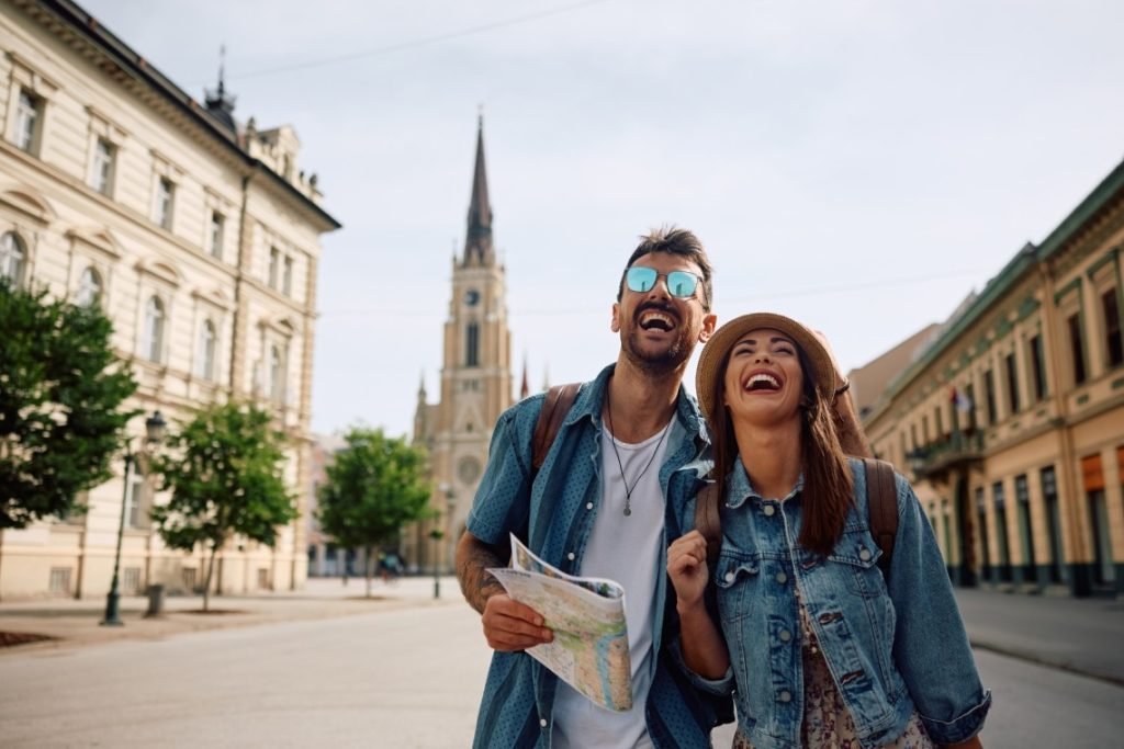 Young,Couple,Of,Travelers,Laughing,And,Having,Fun,While,Walking