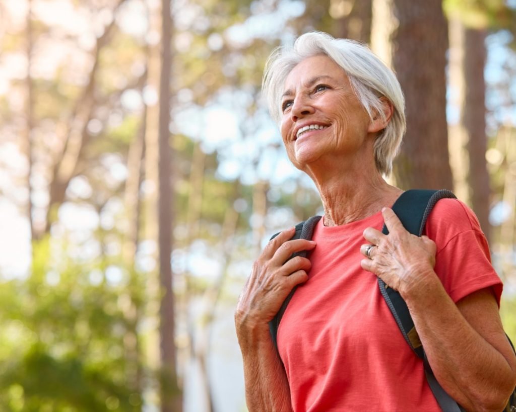 Active,Senior,Woman,On,Outdoor,Hike,In,Countryside,With,Backpack