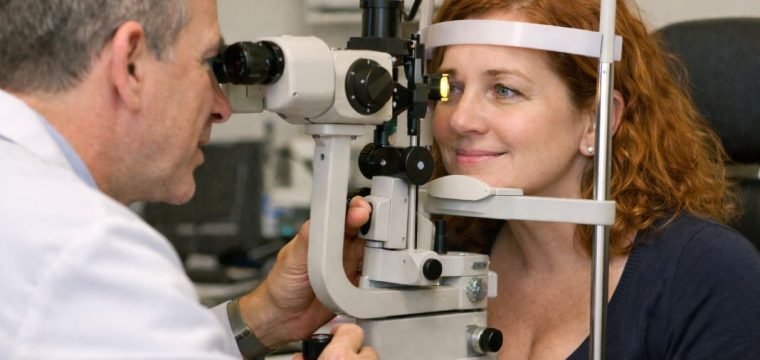 An illustrative image of a slit lamp examination in progress focusing on the equipment and the patient seated comfortably during the check up